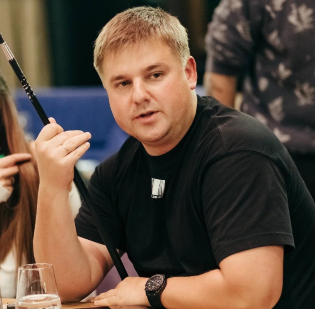 Житель Днепра Максим Филипповский, одетый в чёрную футболку, сидит за столом Житель Днепра Максим Филипповский, одетый в чёрную футболку, сидит за столом
