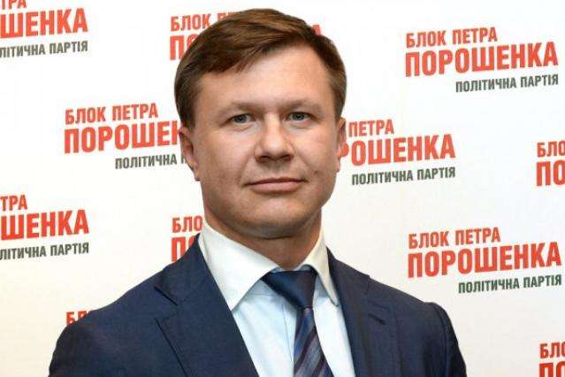 Руслан Демчак під час передвиборчої кампанії 2014 року на фоні плакату Блок Петра Порошенка